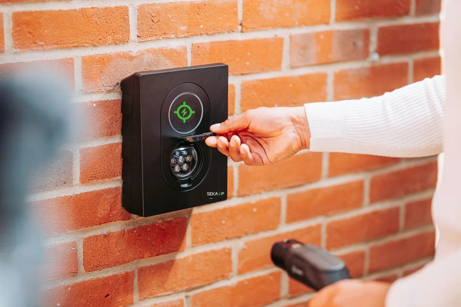 Un badge RFID passé devant une borne murale pour démarrer la recharge